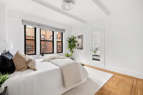 a bedroom with a bed and a potted plant