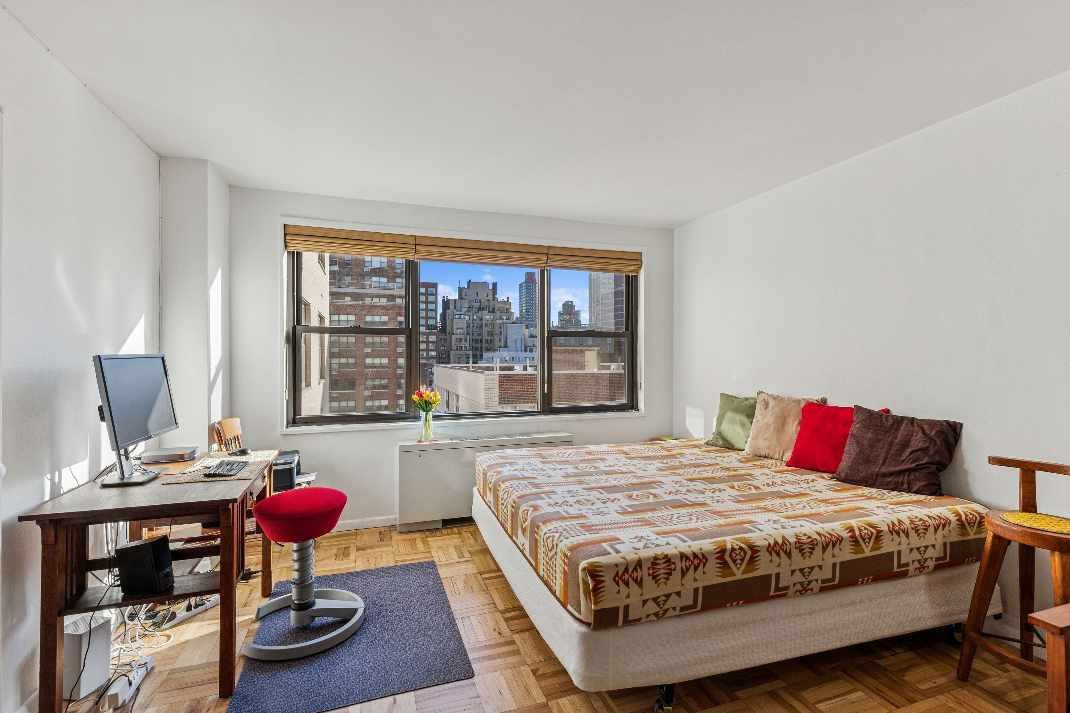 301 East 69th Street, Unit 14A Manhattan, NY 10021 - Photo 2 of 13 a bedroom with a bed window and a table
