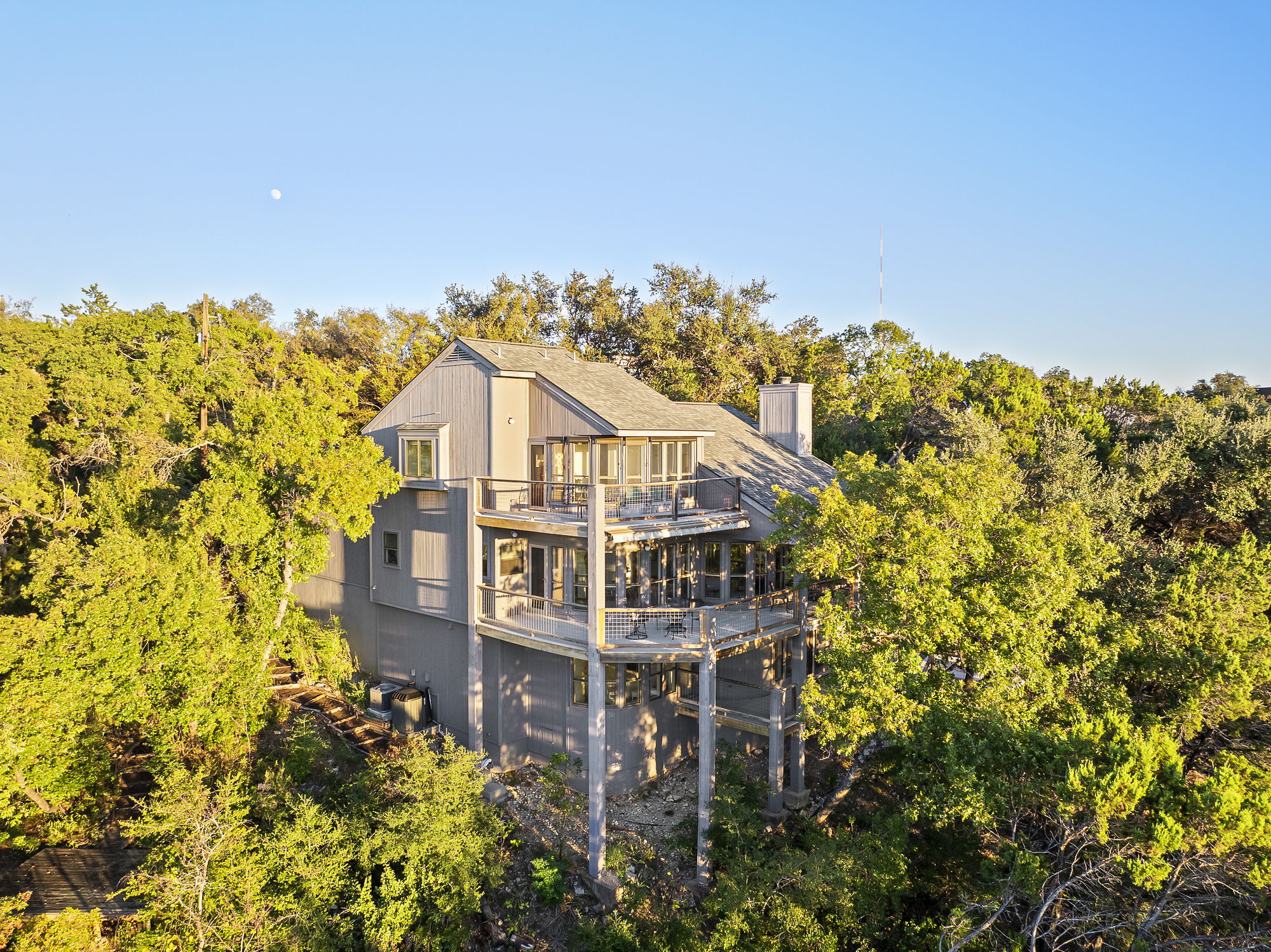 a view of a house with a big yard and large trees