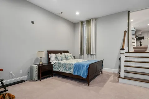 a view of a backyard with large trees and wooden fence