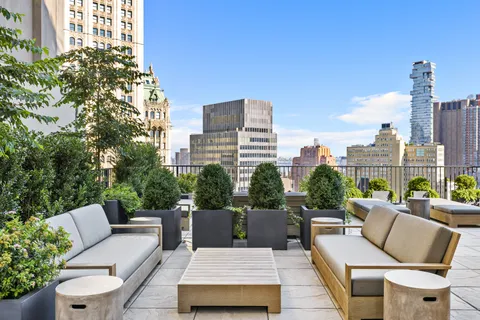 a view of a roof deck with couches and potted plants