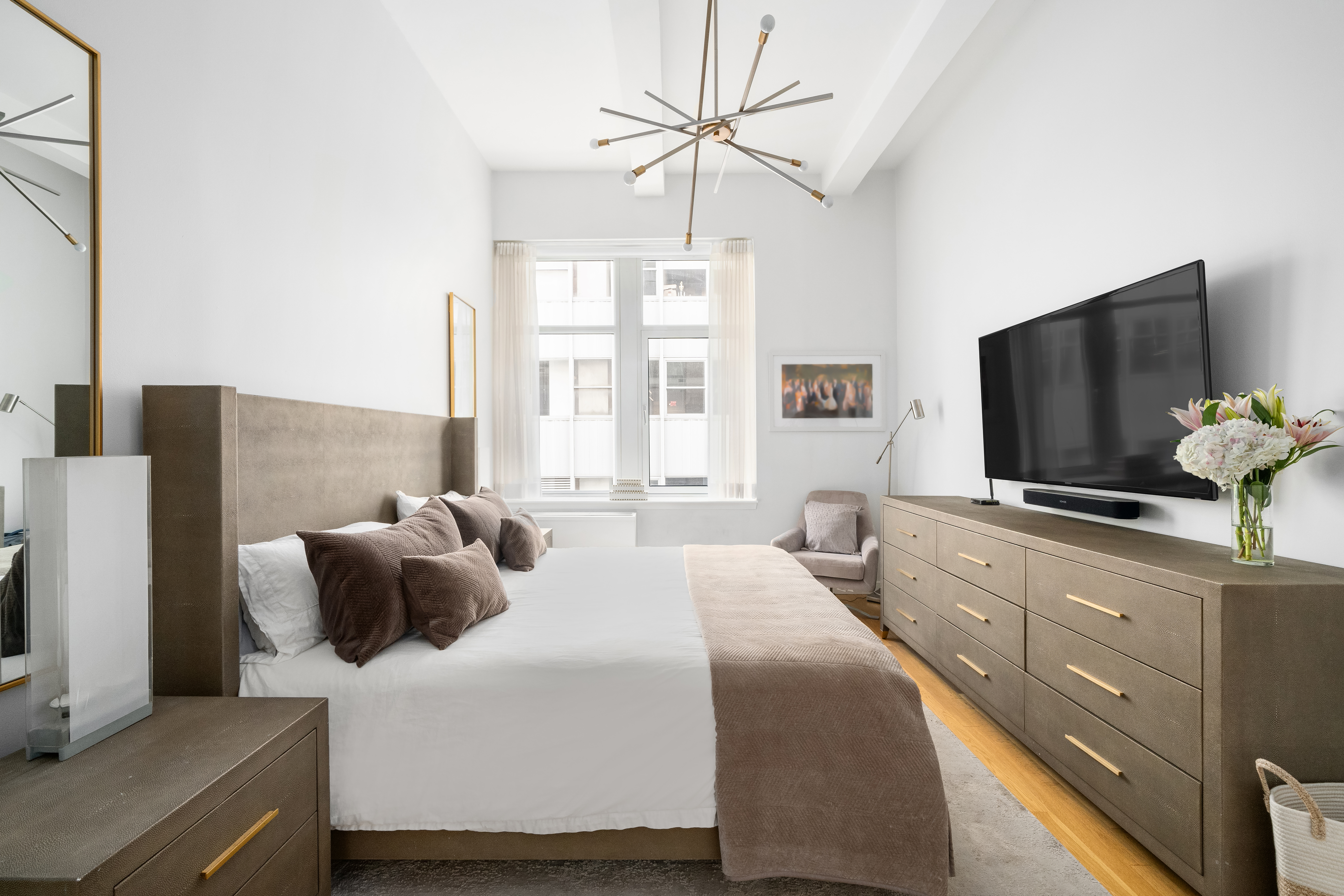 59 John Street, Unit 7D Manhattan, NY 10038 - Photo 5 of 10 a bedroom with a bed and a flat screen tv
