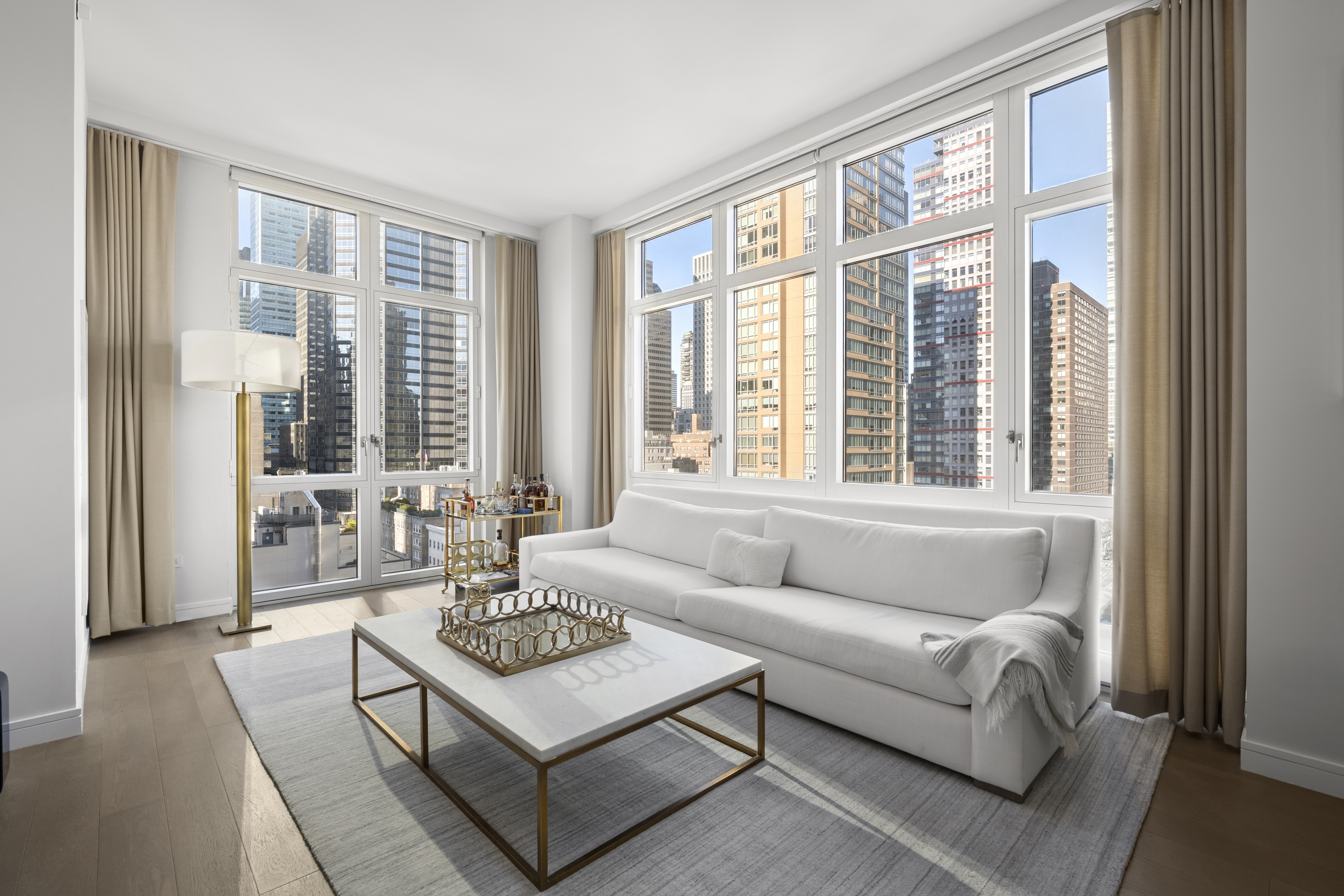 305 East 51st Street, Unit 11D Manhattan, NY 10022 - Photo 2 of 18 a living room with furniture and large windows