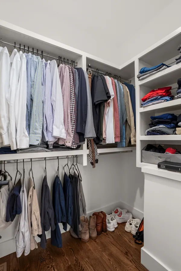 a view of walk in closet with clothes and shoes