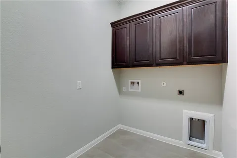 an empty room with windows and chandelier fan