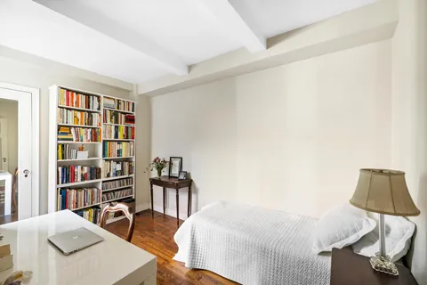 a bedroom with a bed and a book shelf