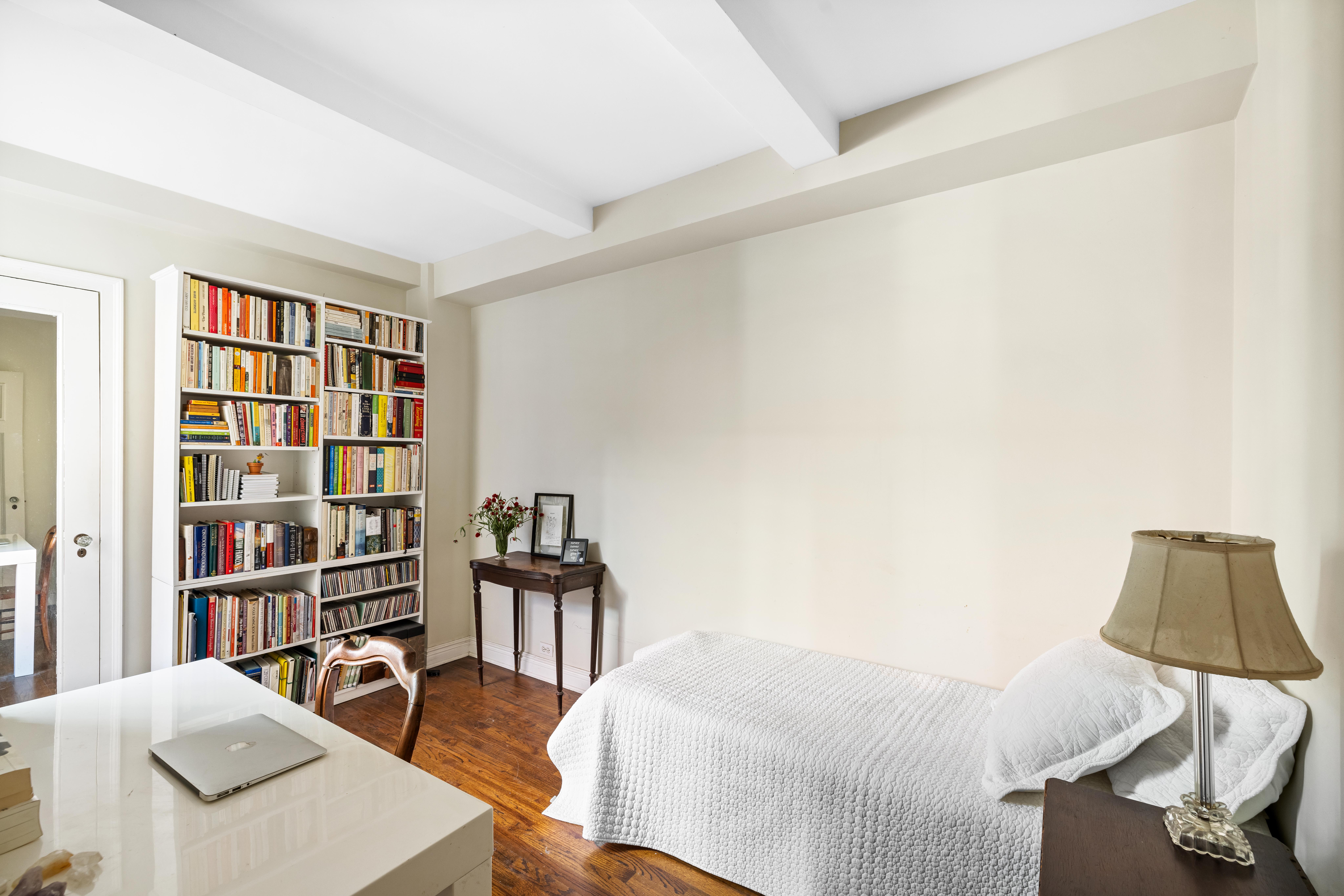 333 East 43rd Street, Unit 922 Manhattan, NY 10017 - Photo 9 of 14 a bedroom with a bed and a book shelf