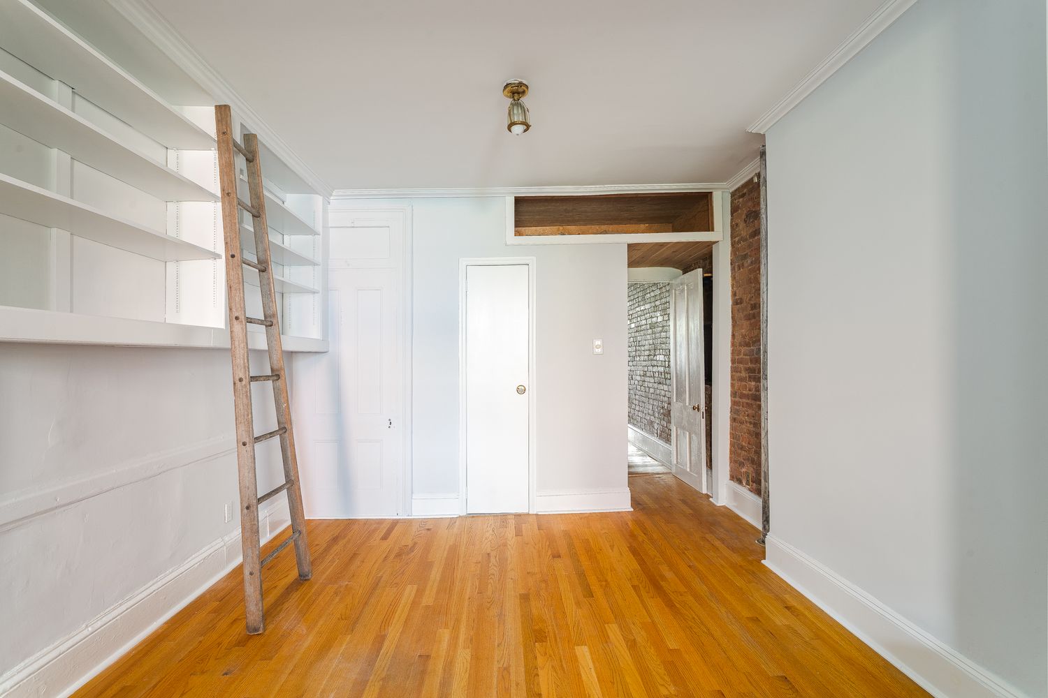 a view of empty room with wooden floor and entryway