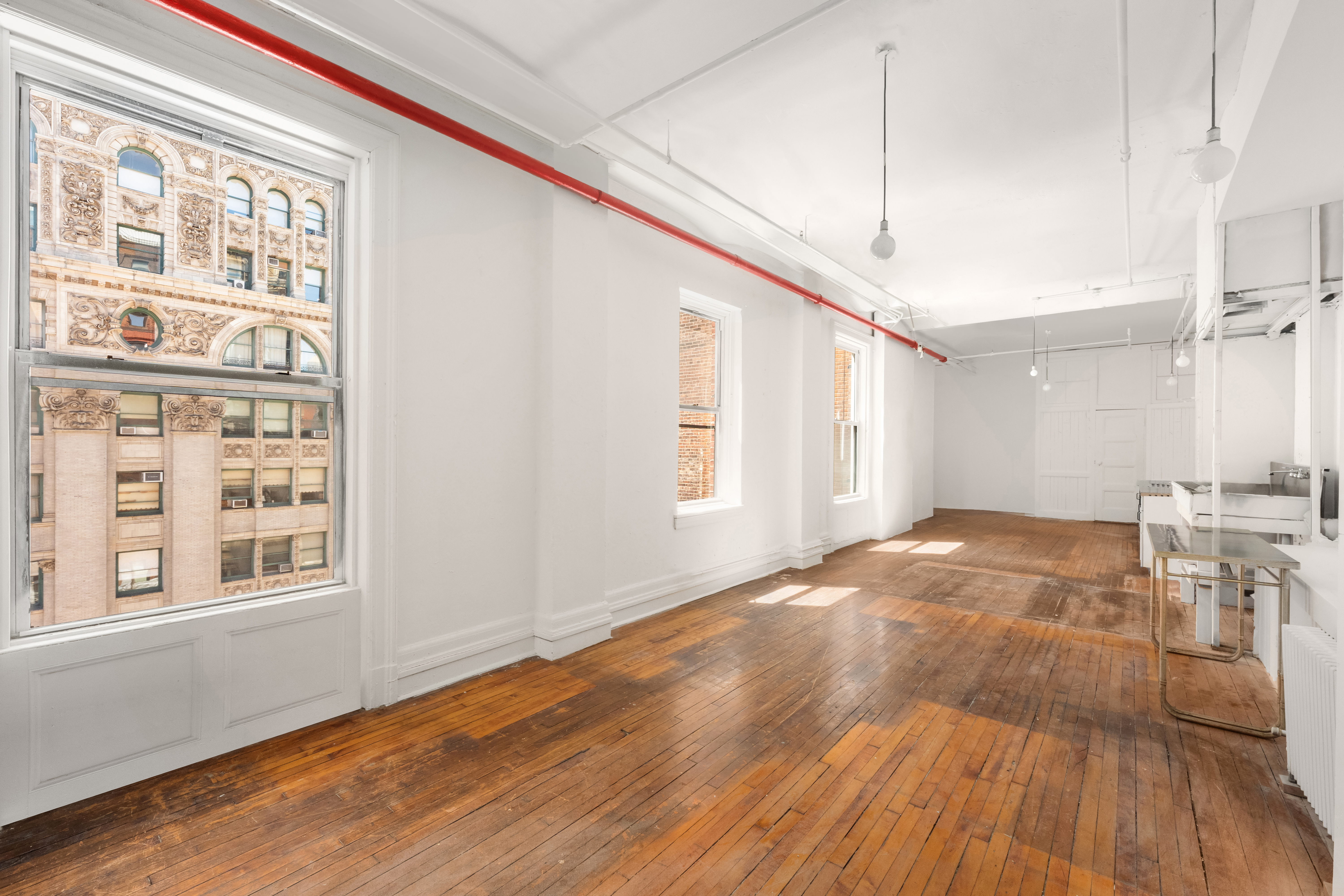 491 Broadway Manhattan, NY 10012 - Photo 7 of 11 a view of an empty room with wooden floor and a window