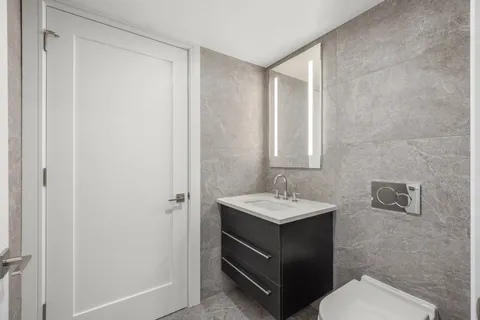 a bathroom with a sink a toilet and mirror