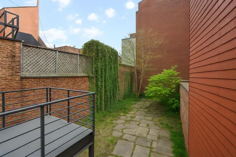 a view of balcony with wooden floor and fence and a bench