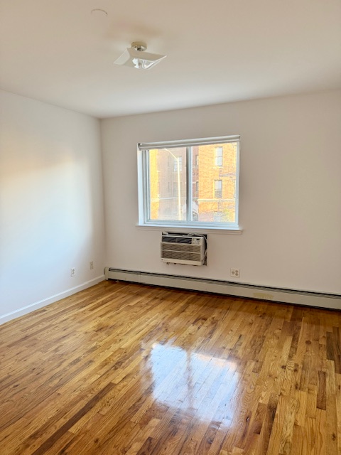 30-18 33rd Street, Unit 2F Queens, NY 11102 - Photo 3 of 6 a view of an empty room with wooden floor and a window