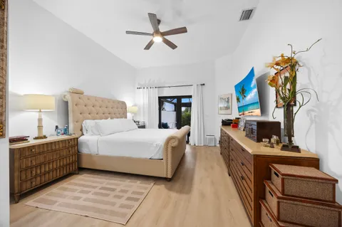 a bedroom with a bed and a flat tv screen on dresser
