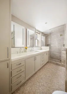 a spacious bathroom with a double vanity sink a mirror and a shower