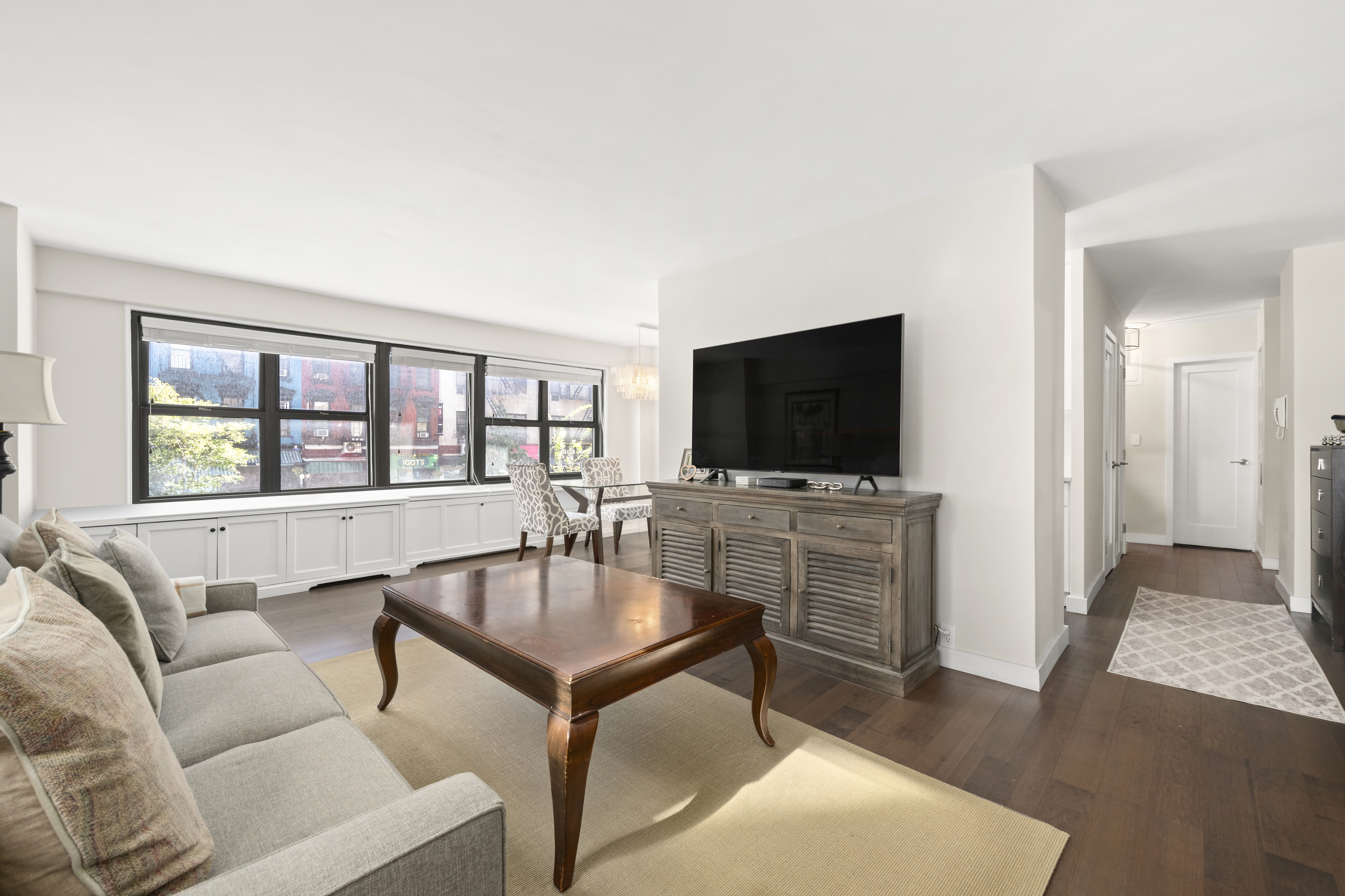 240 East 76th Street, Unit 2E Manhattan, NY 10021 - Photo 2 of 11 a living room with furniture and a flat screen tv