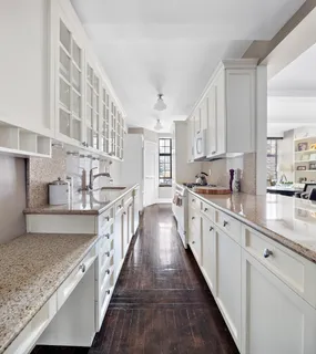 a large kitchen with stainless steel appliances granite countertop a lot of counter space and wooden floors