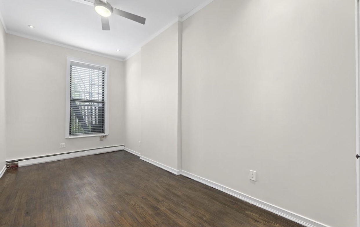 290 Hancock Street, Unit 1 Brooklyn, NY 11216 - Photo 2 of 6 an empty room with wooden floor and windows