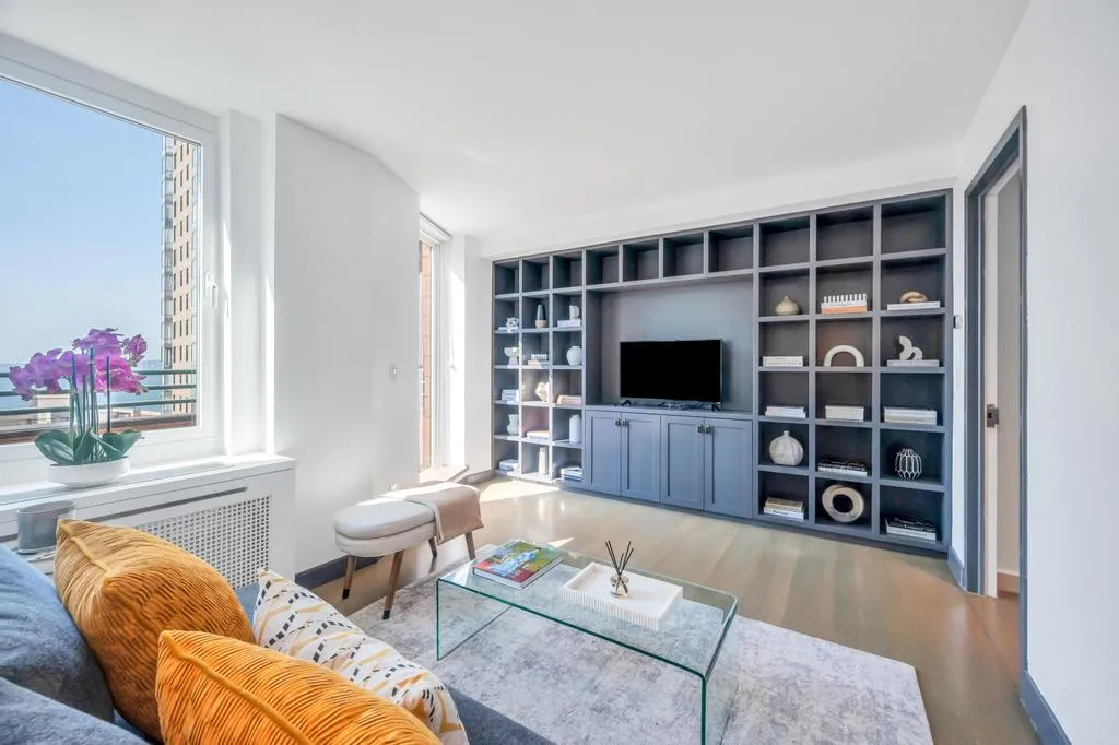 a living room with furniture a flat screen tv and a table
