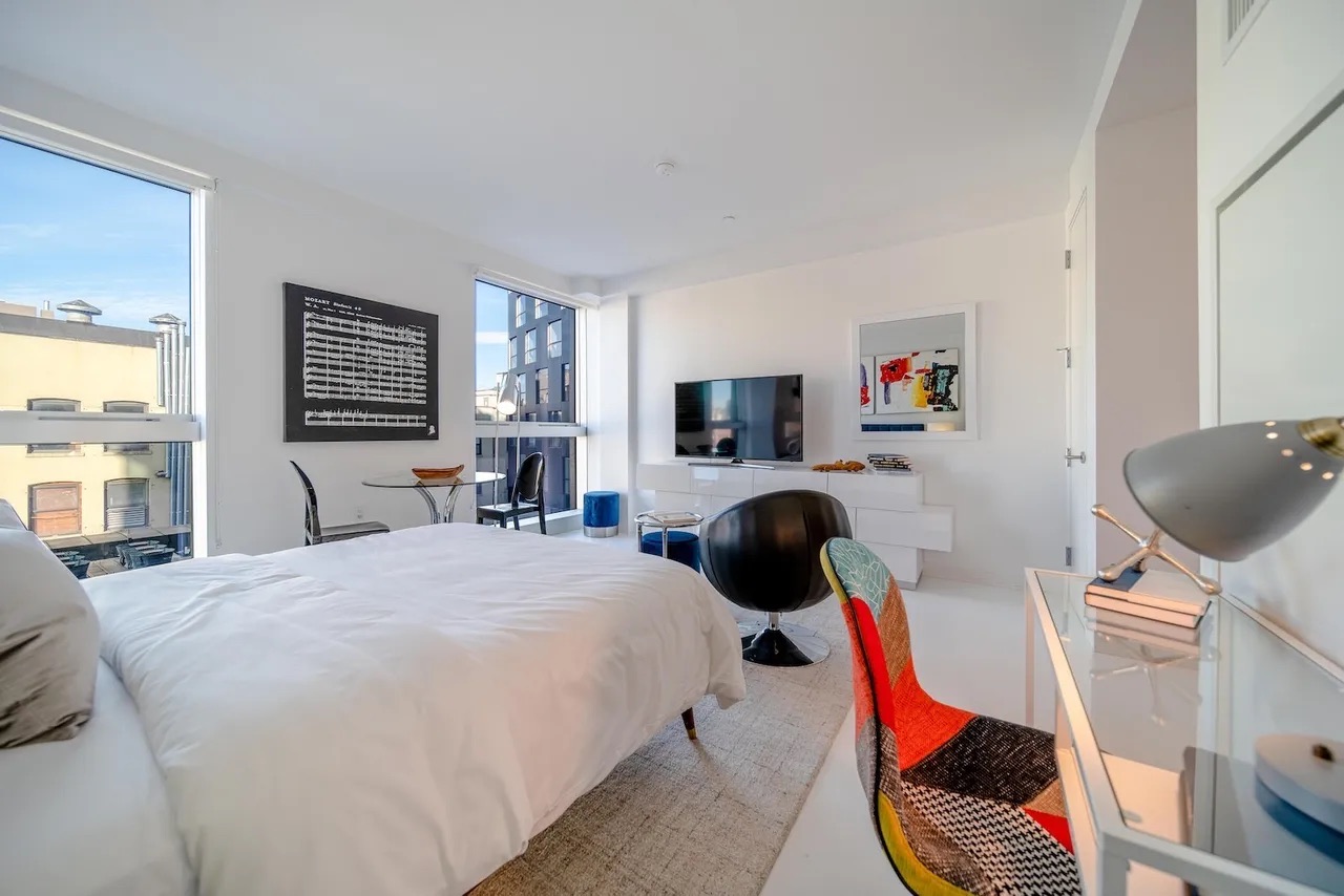 158 East 126th Street, Unit 730 Manhattan, NY 10035 - Photo 5 of 18 a bedroom with furniture and a flat screen tv