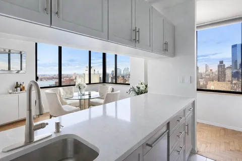 a view with granite countertop a sink and a counter top space in the room