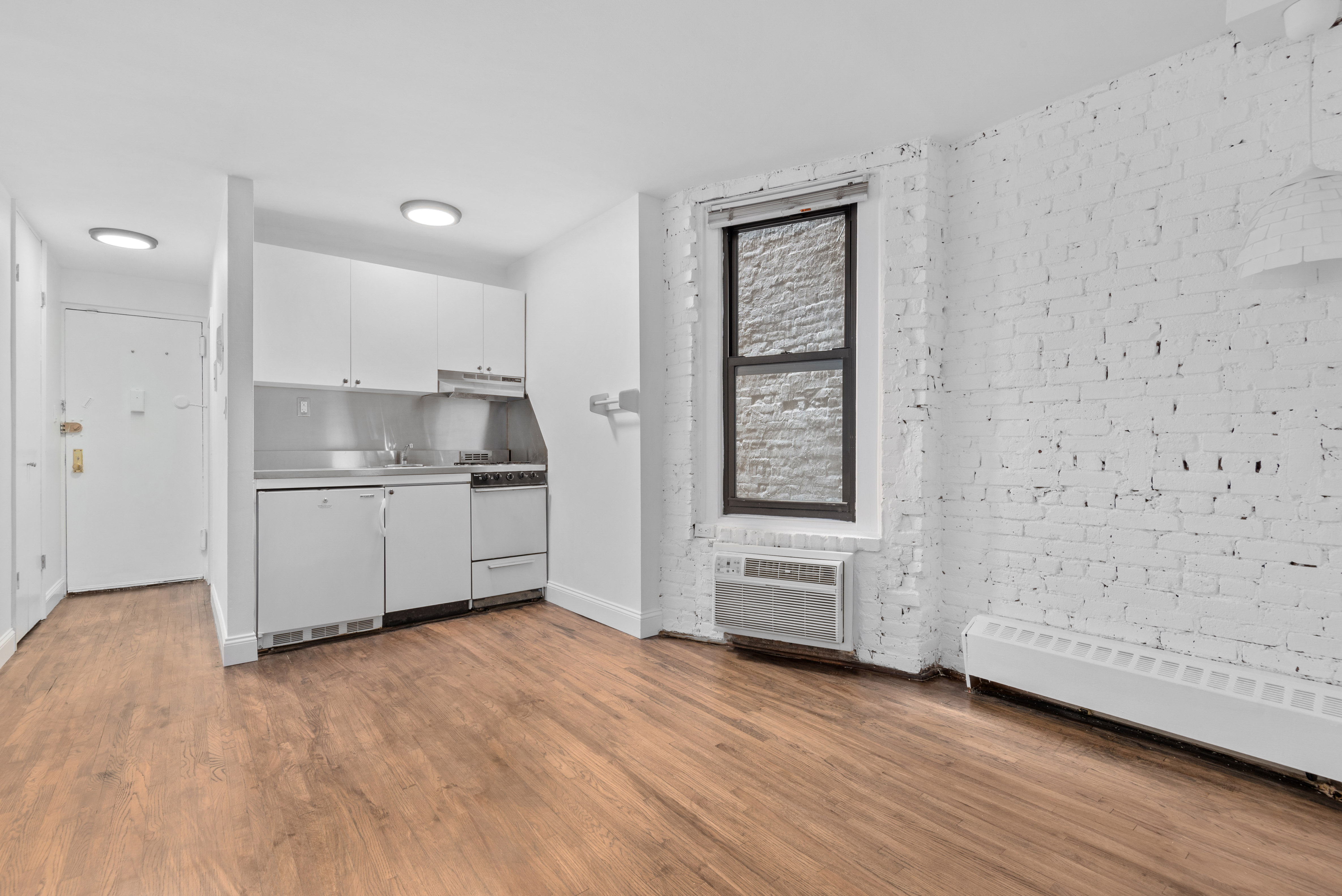 15 Jones Street, Unit 3C Manhattan, NY 10014 - Photo 2 of 5 a view of kitchen with wooden floor and electronic appliances