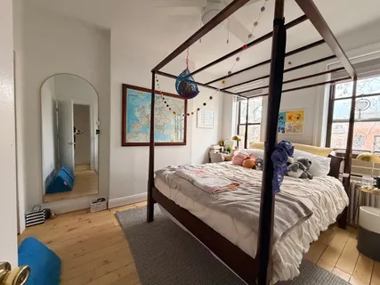 a bed sitting in a bedroom next to a window