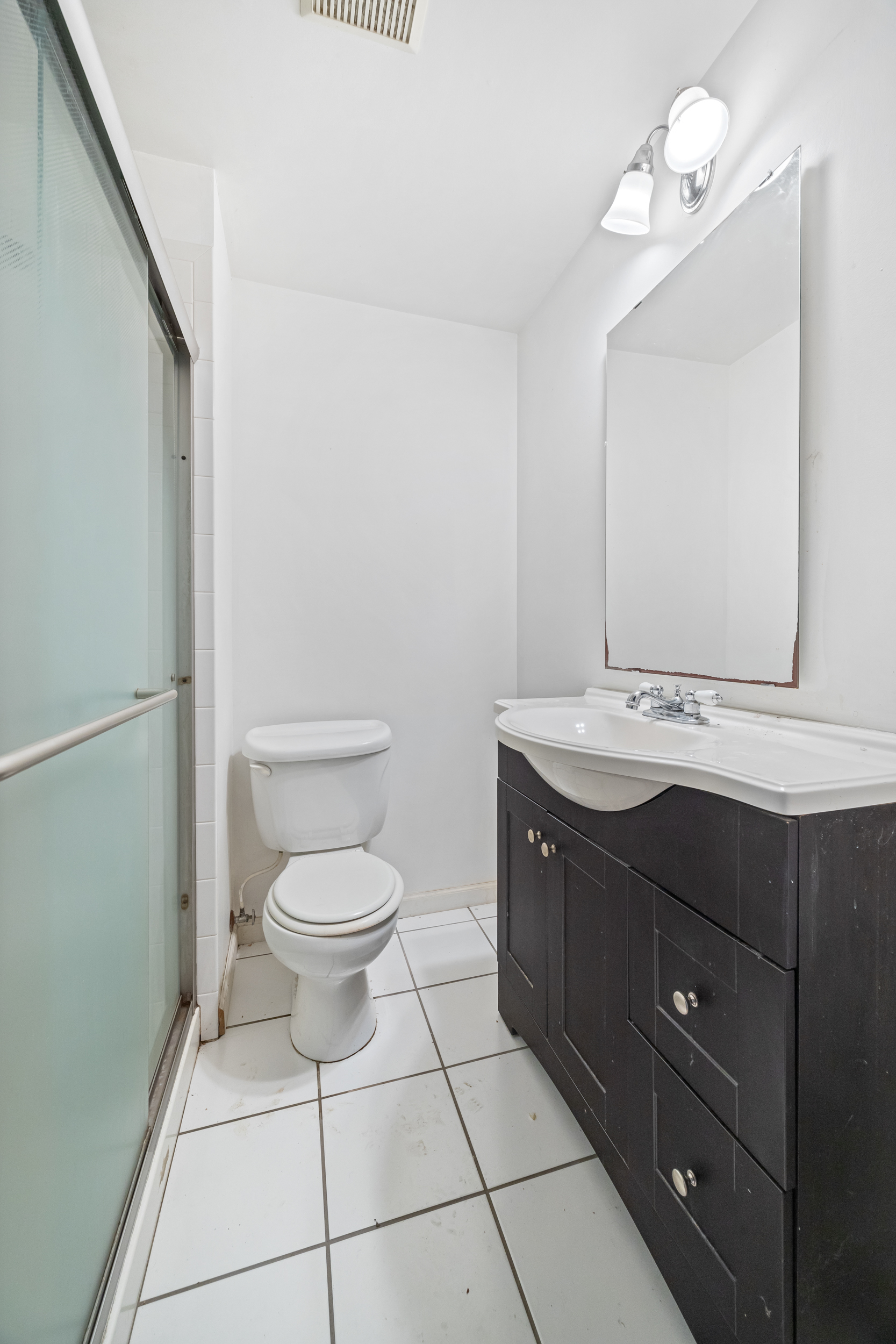 961 Lorimer Street, Unit 2 Brooklyn, NY 11222 - Photo 5 of 5 a bathroom with a granite countertop toilet sink and mirror