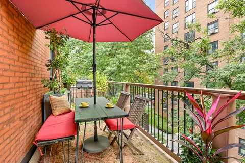 a view of balcony with furniture and umbrella