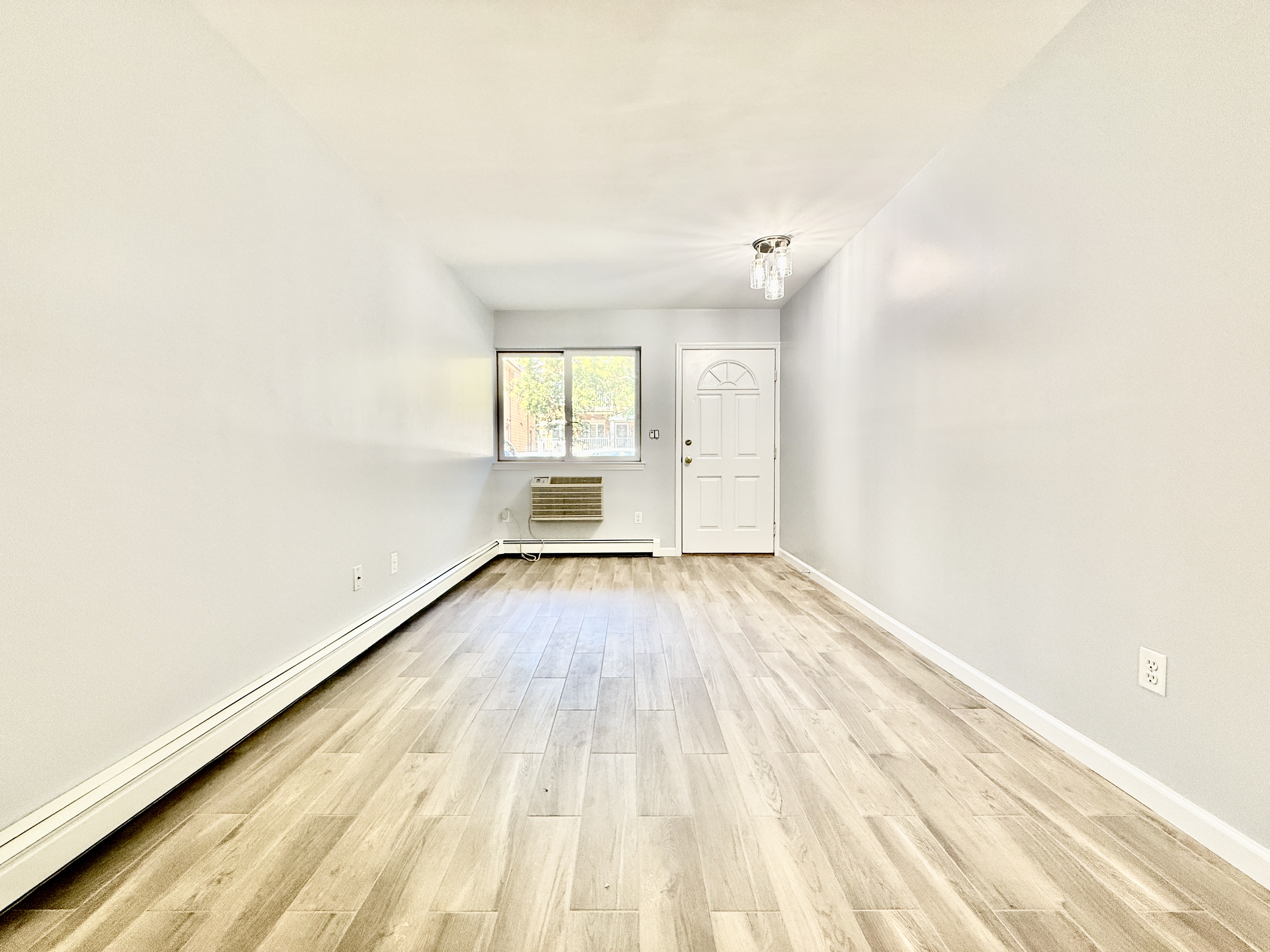a view of a room with wooden floor and a window