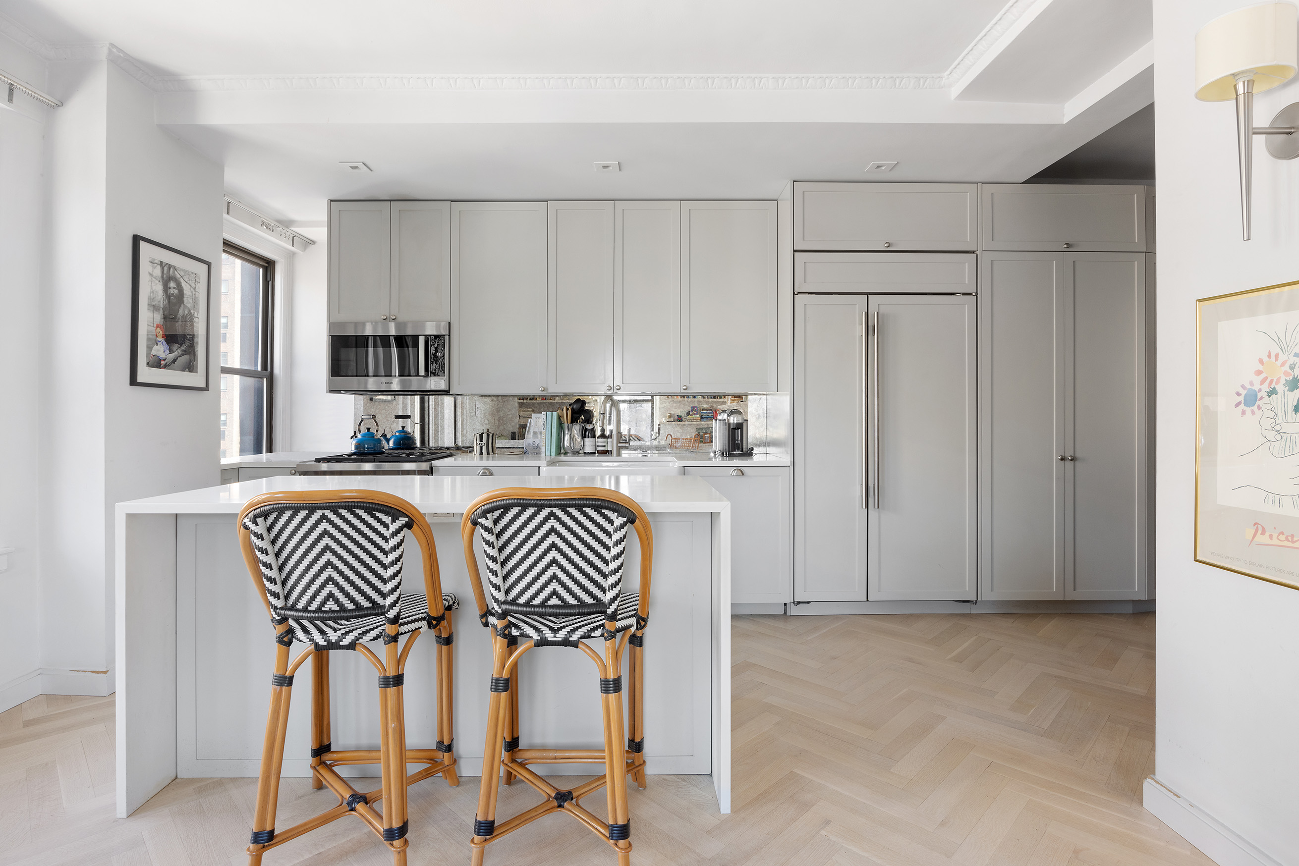 26 East 10th Street, Unit 11G Manhattan, NY 10003 - Photo 6 of 14 a kitchen with kitchen island white cabinets and stainless steel appliances