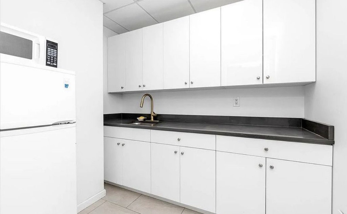 142-38 37th Avenue, Unit 2G Flushing, NY 11354 - Photo 5 of 8 a kitchen with granite countertop white cabinets and white appliances