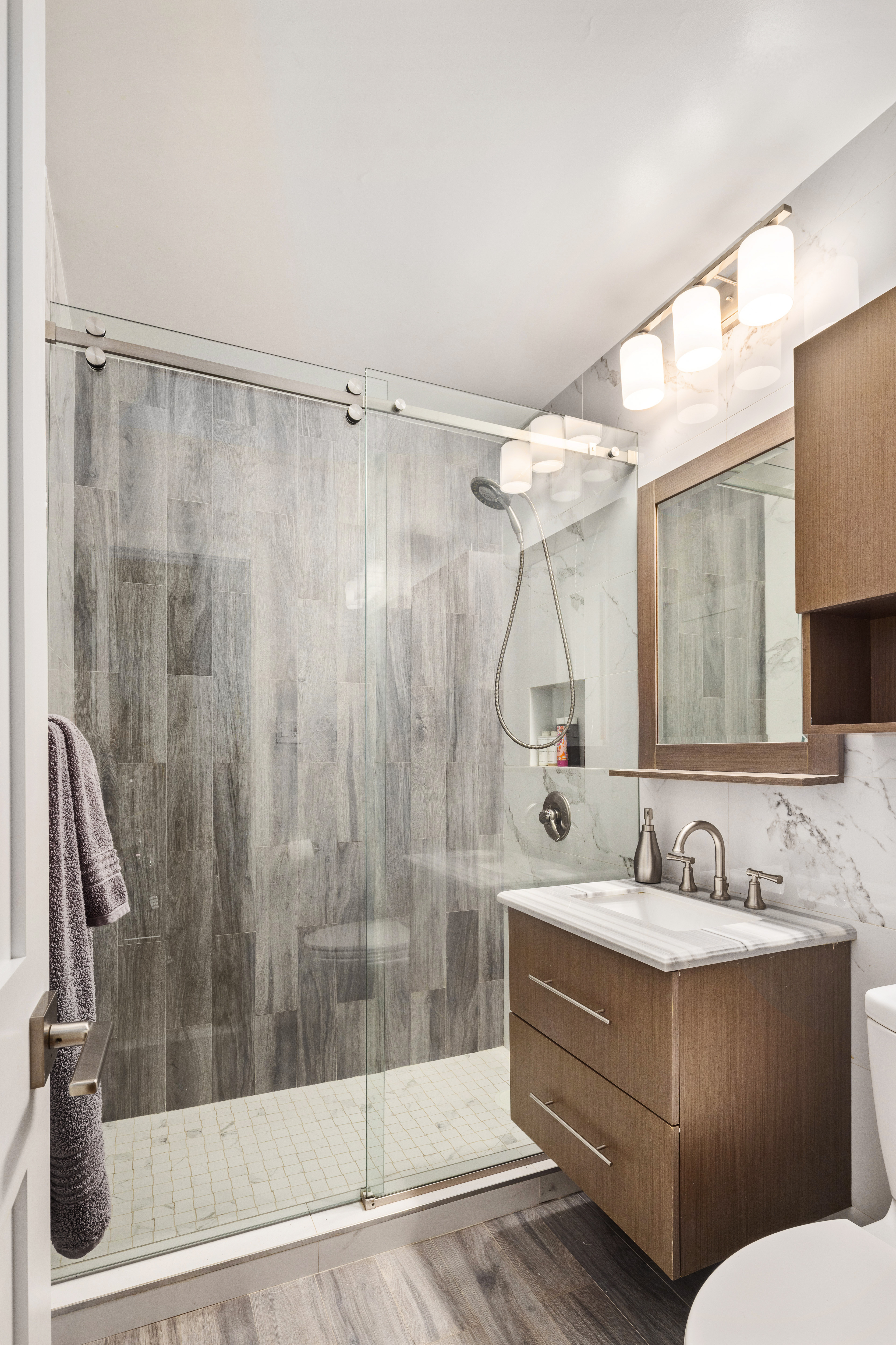 159 West 53rd Street, Unit 34E Manhattan, NY 10019 - Photo 11 of 15 a bathroom with a sink mirror and a shower