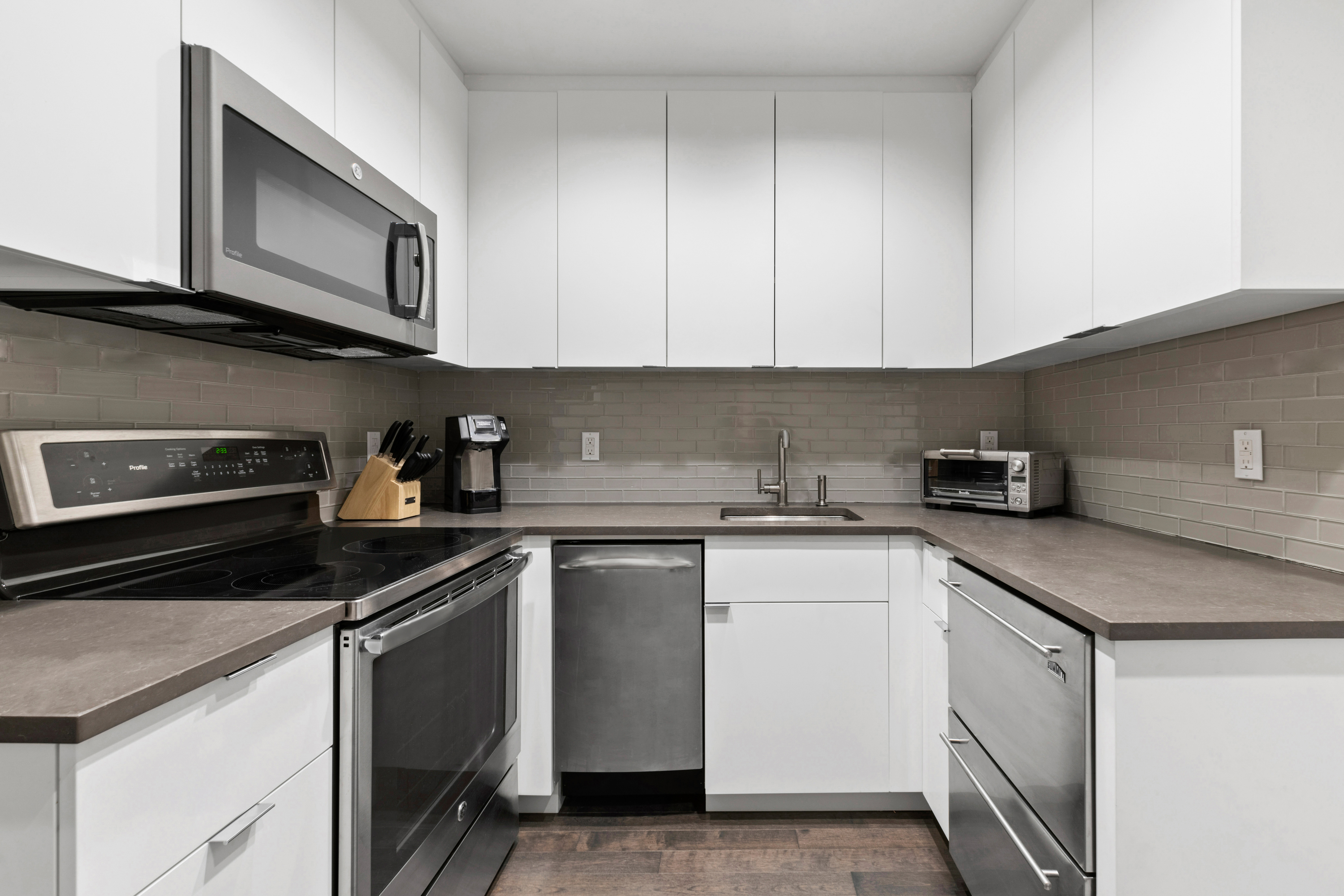 1 West 67th Street, Unit 206 Manhattan, NY 10023 - Photo 4 of 13 a kitchen with cabinets stainless steel appliances and a sink
