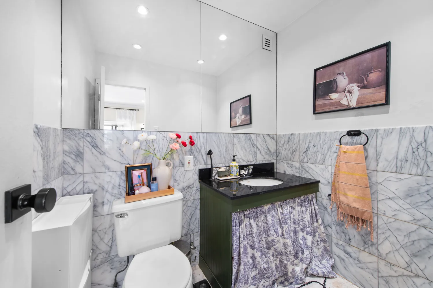 a bathroom with a granite countertop toilet sink and mirror