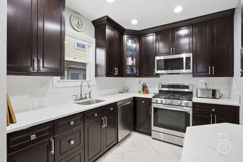 a kitchen with stainless steel appliances granite countertop a sink and stove top oven
