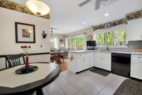 a kitchen with sink white cabinets and window
