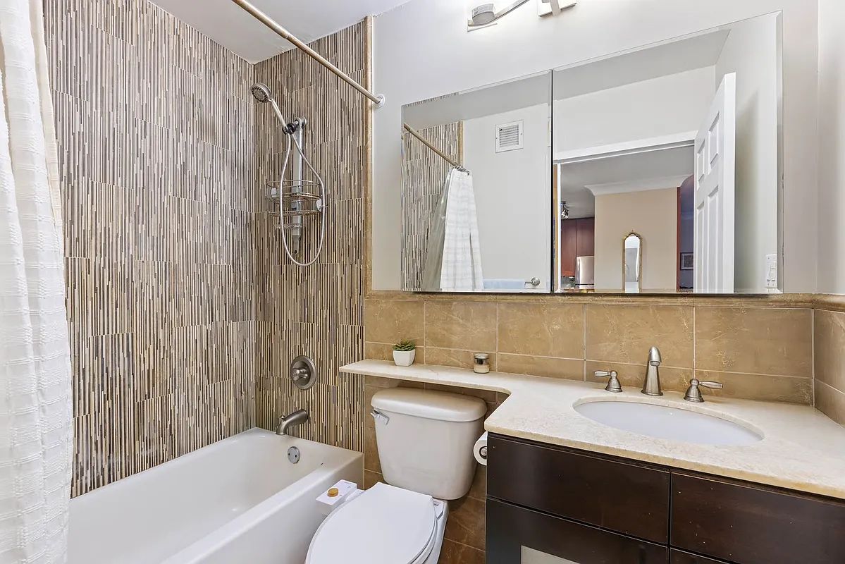 a bathroom with a sink toilet vanity and tub