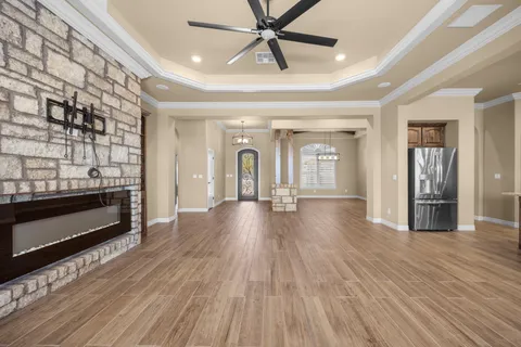 a large kitchen with kitchen island granite countertop a refrigerator and cabinets