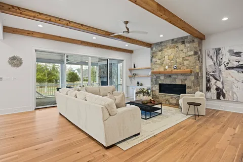 a living room with furniture large window and a fireplace
