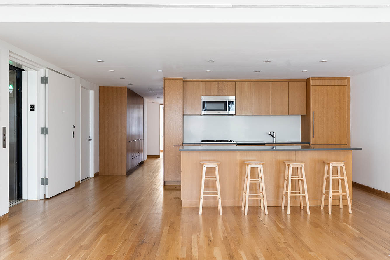 75 Sullivan Street, Unit 5S Manhattan, NY 10012 - Photo 2 of 12 a kitchen with stainless steel appliances granite countertop a stove a sink a refrigerator with white cabinets and wooden floor