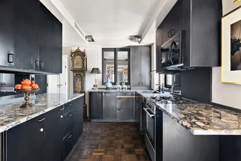 a kitchen with stainless steel appliances granite countertop a sink stove and cabinets