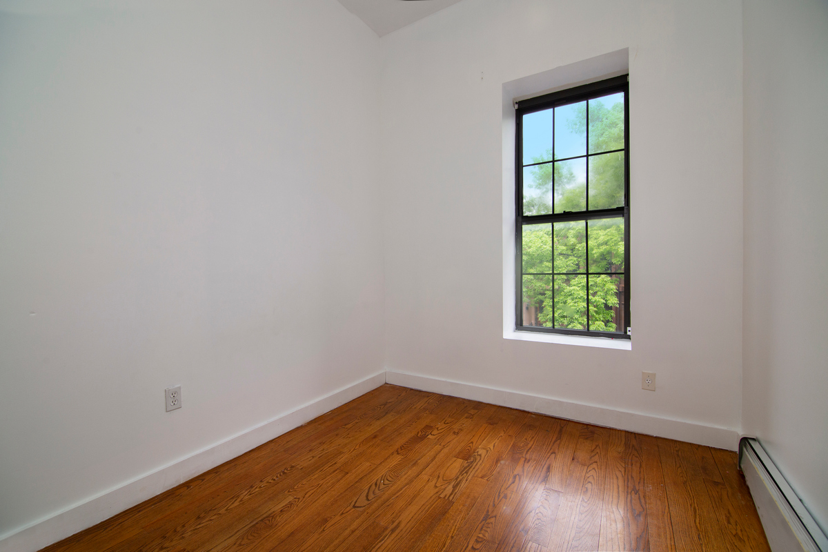900 Lafayette Avenue Brooklyn, NY 11221 - Photo 11 of 13 an empty room with wooden floor and windows