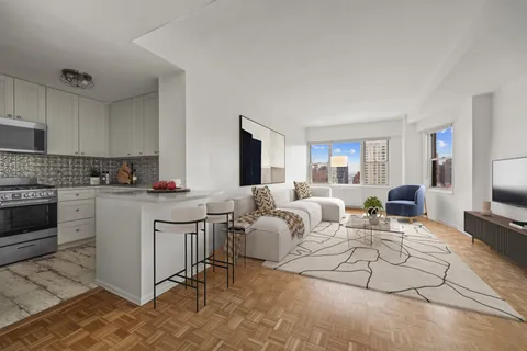 a living room with furniture white walls and kitchen view