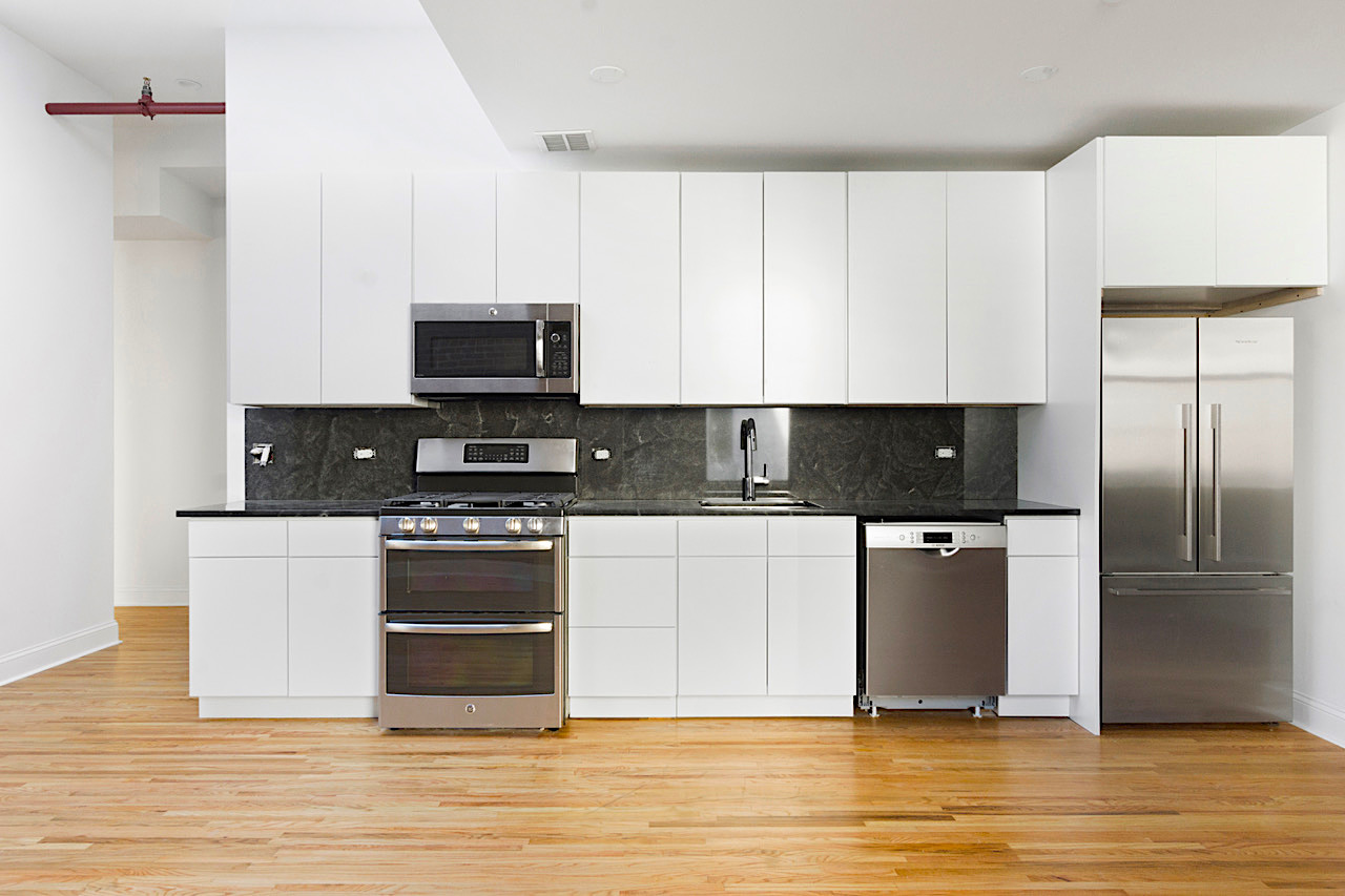 281 Grand Street, Unit 2R Manhattan, NY 10002 - Photo 1 of 11 a kitchen with stainless steel appliances granite countertop a stove a sink and a refrigerator