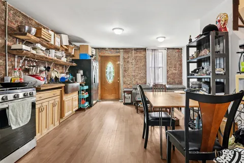 a kitchen with stainless steel appliances wooden floor dining table and chairs