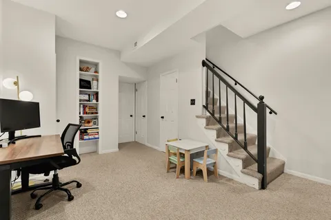 a view of a workspace with furniture and a window