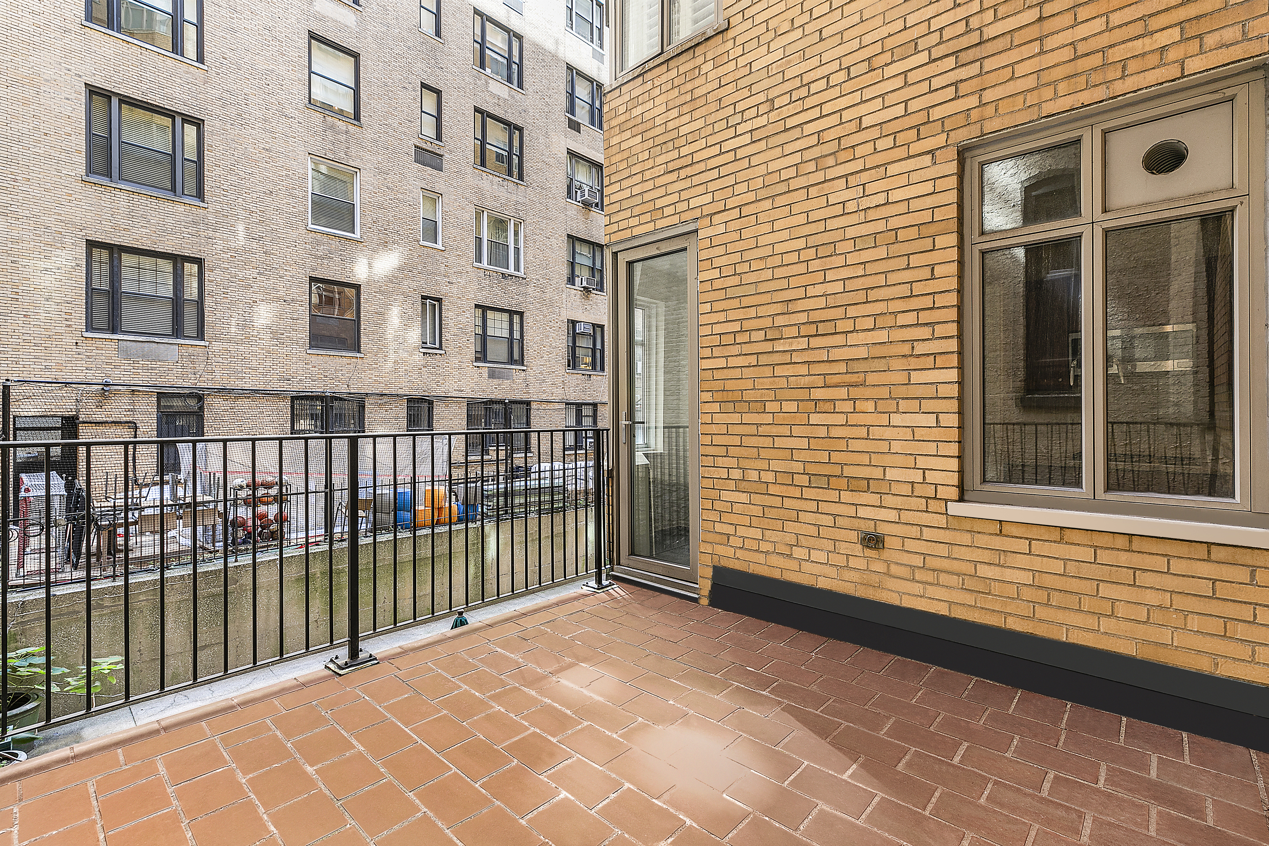 65 East 76th Street, Unit 1C Manhattan, NY 10021 - Photo 5 of 6 a view of a brick building next to a yard