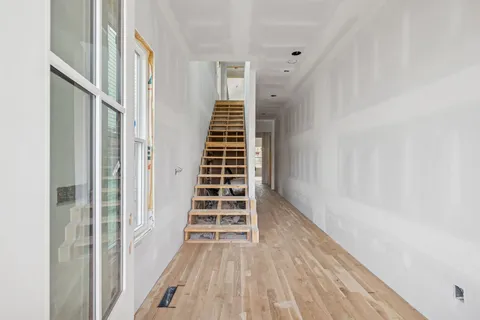 a view of a hallway with wooden floor and entryway