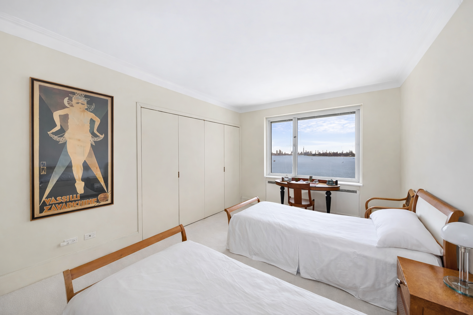 25 Sutton Place South, Unit 8G Manhattan, NY 10022 - Photo 15 of 22 a bedroom with a bed and a lamp on dresser