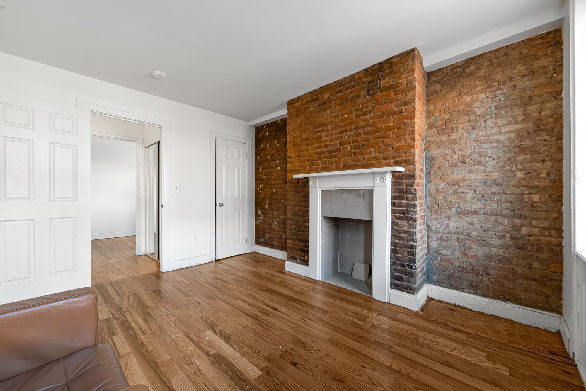 504 East 6th Street, Unit 6 Manhattan, NY 10009 - Photo 7 of 19 a view of empty room with wooden floor and fireplace